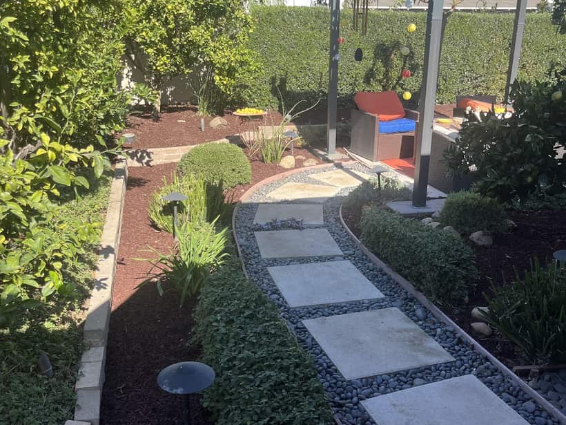 Paver walkway set in pebble between mulched beds